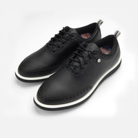 Pair of black leather shoes with white soles on a light gray background sells at Paradise Golf