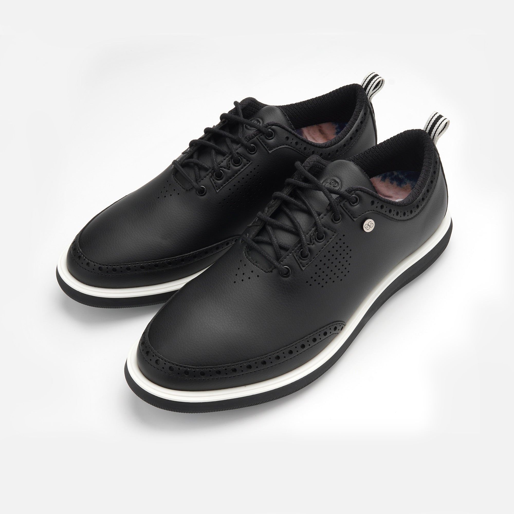 Pair of black leather shoes with white soles on a light gray background sells at Paradise Golf