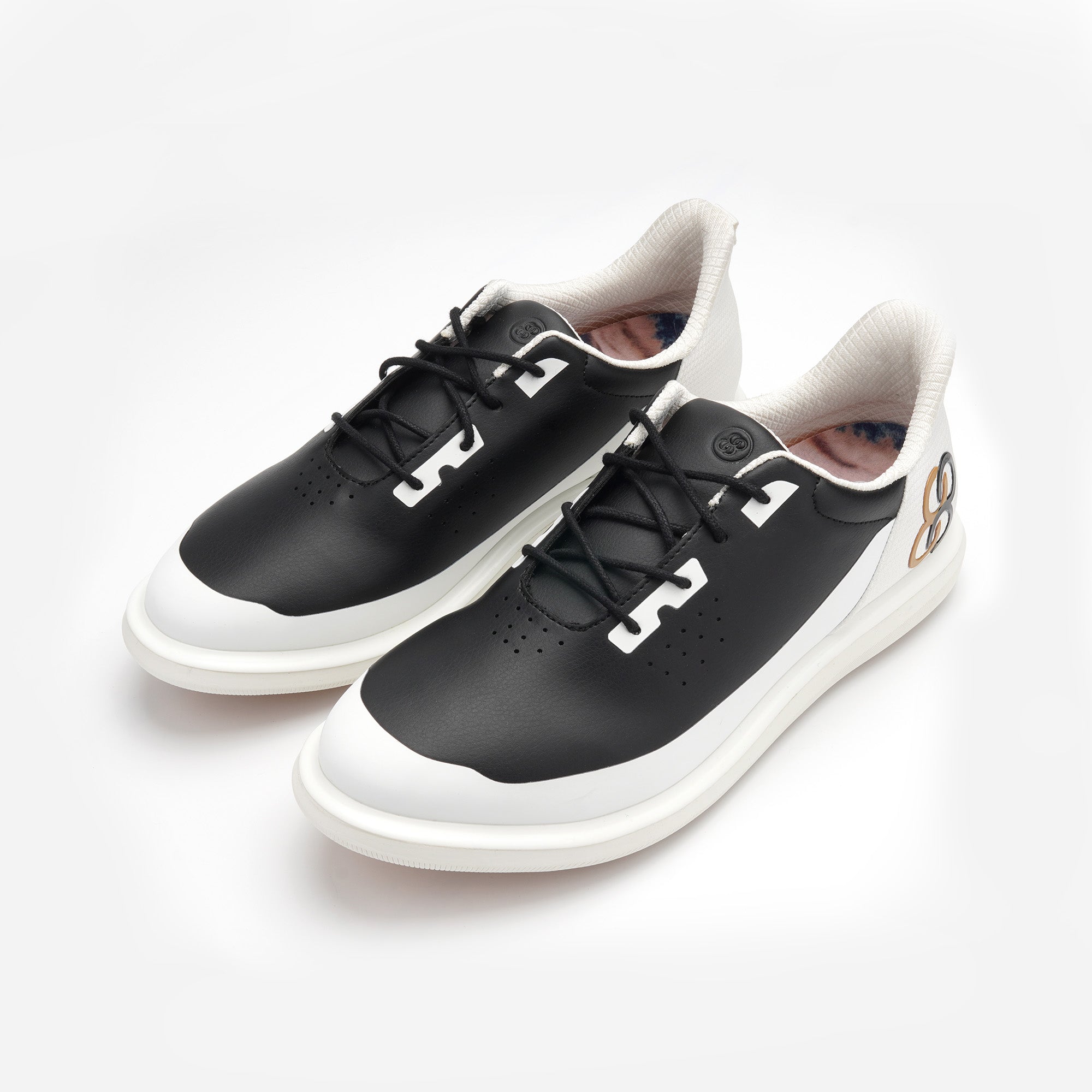 Black and white sneakers on a white background sells at Paradise Golf