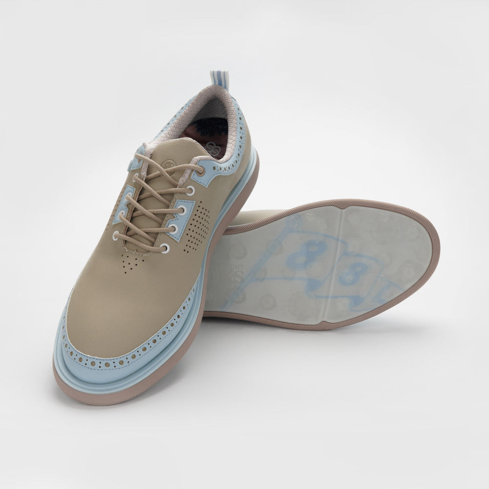 A pair of tan and blue shoes on a white background sells at Paradise Golf