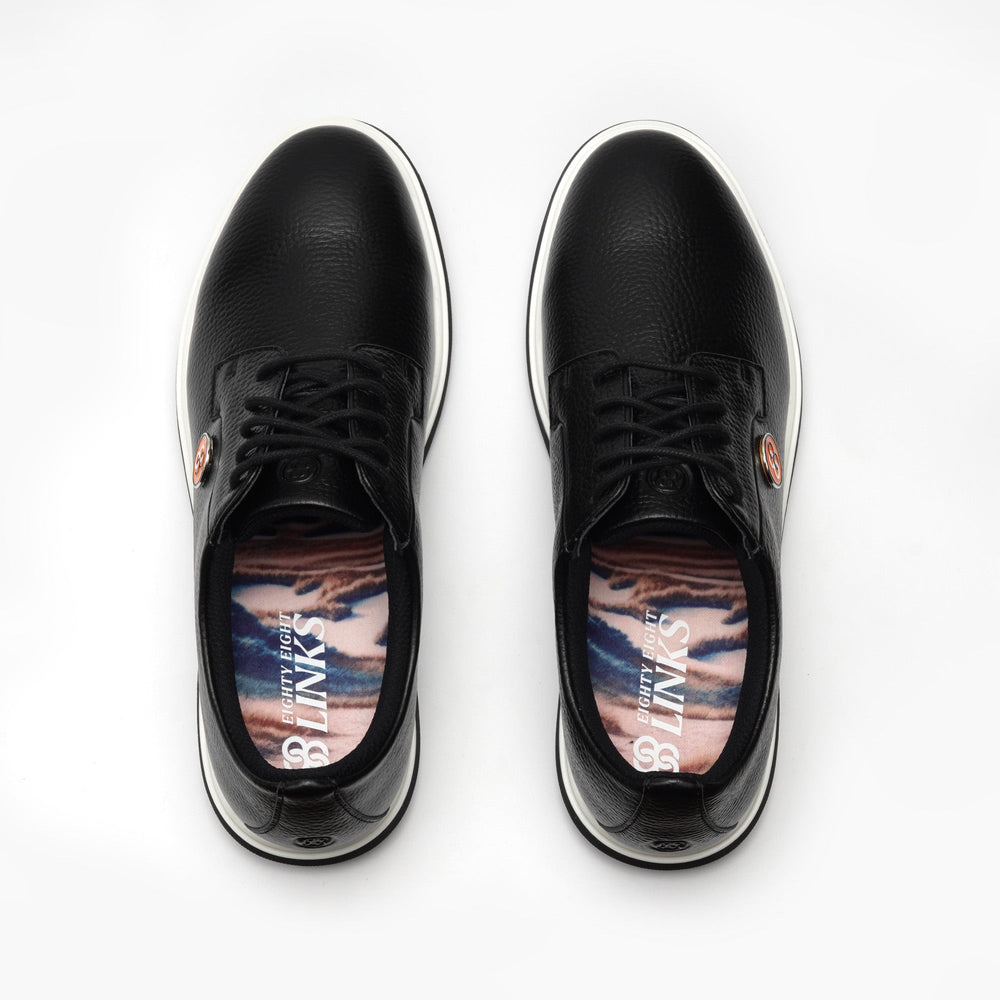 Black sneakers with colorful sole patterns on a white background sells at Paradise Golf