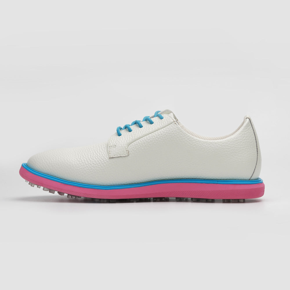 White sneaker with blue laces and pink sole on a light gray background sells at Paradise Golf