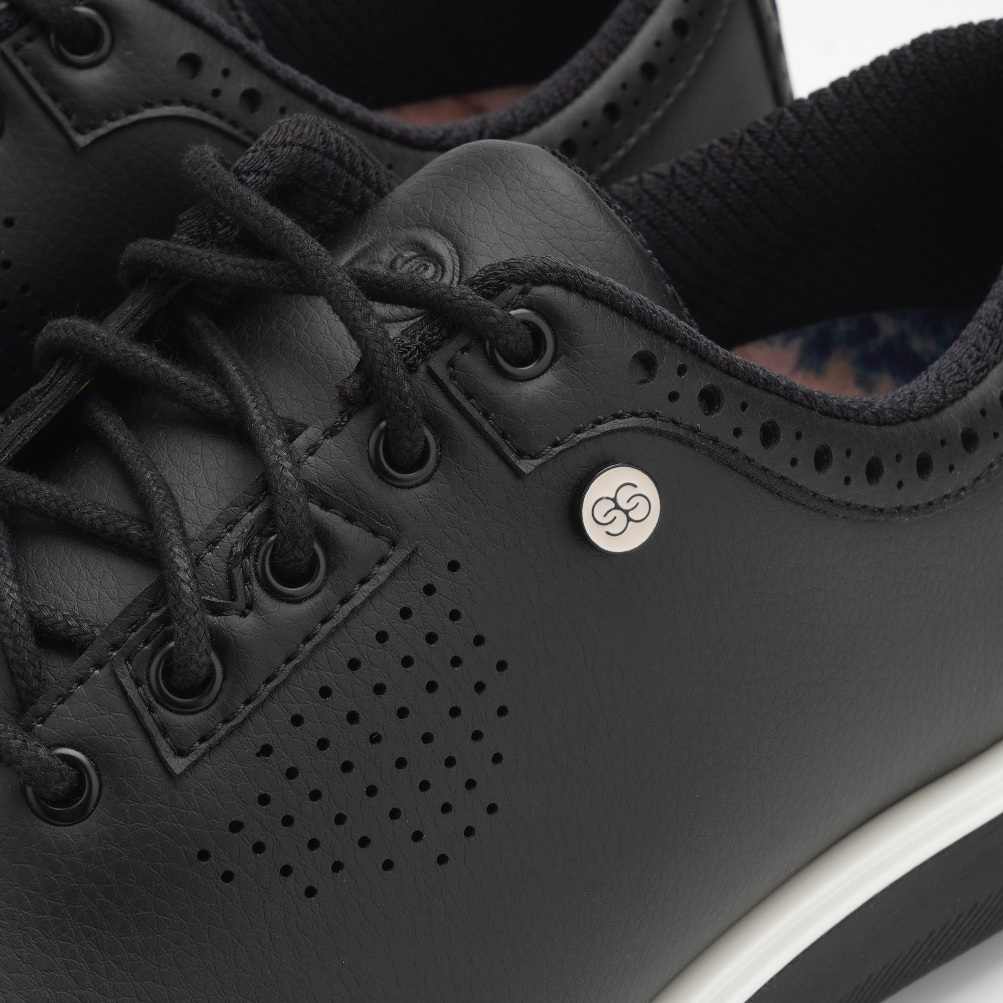Close-up of black sneakers with a brand logo on a white background sells at Paradise Golf
