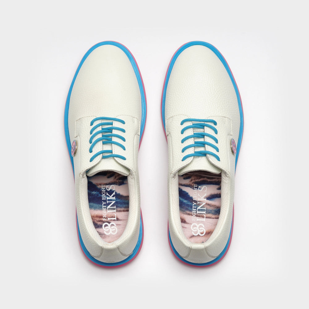 White sneakers with blue accents on a light gray background sells at Paradise Golf