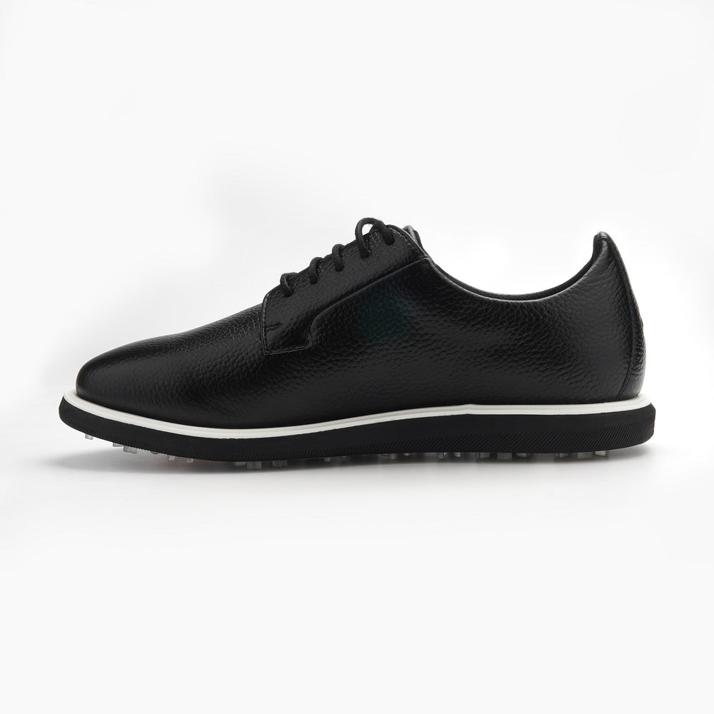 Black leather sneaker with white sole on a light gray background sells at Paradise Golf