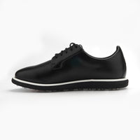 Black leather sneaker with white sole on a light gray background sells at Paradise Golf