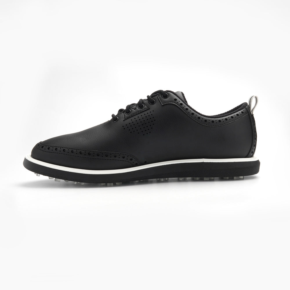 Black leather shoe with white sole on a light gray background sells at Paradise Golf