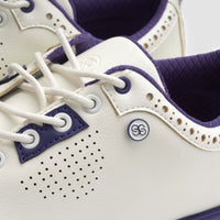 Close-up of a white and purple sneaker with a brand logo on a light background sells at Paradise Golf