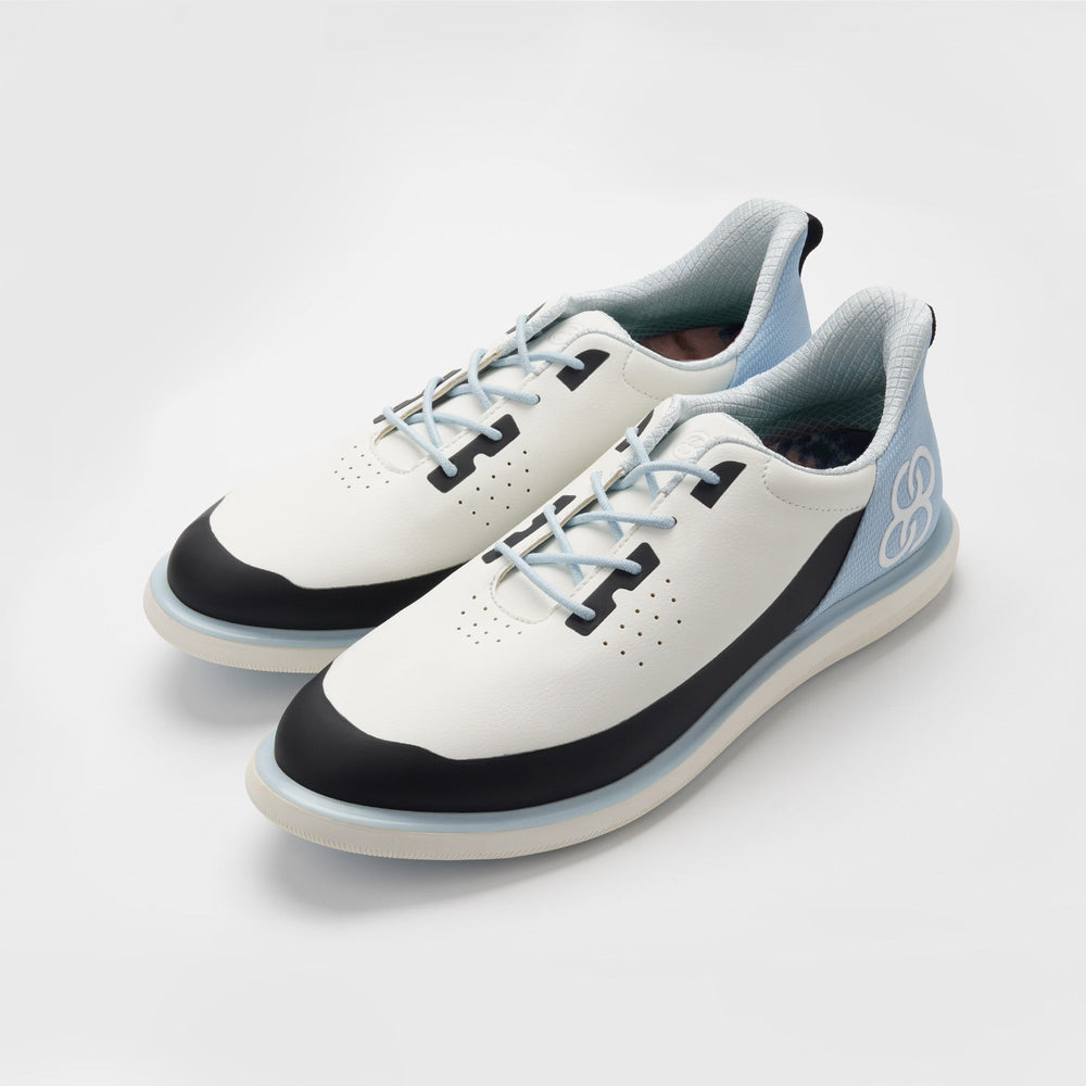White sneakers with black and blue accents on a light gray background sells at Paradise Golf