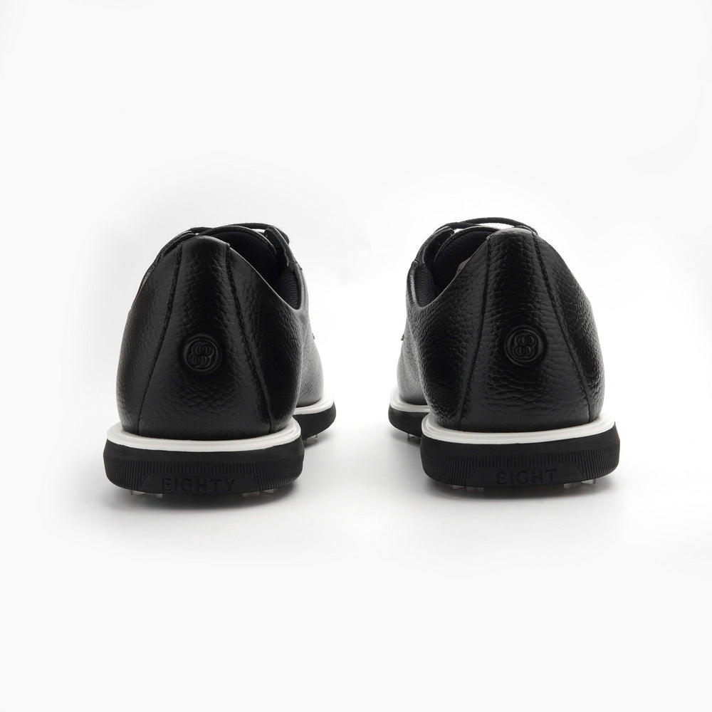Black leather shoes with white soles on a white background sells at Paradise Golf