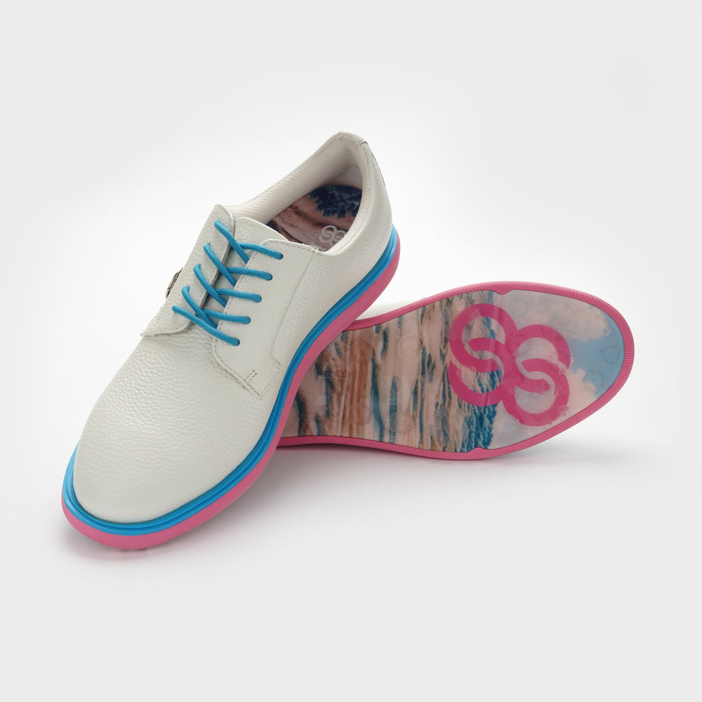 White shoe with blue laces and pink soles on a white background sells at Paradise Golf