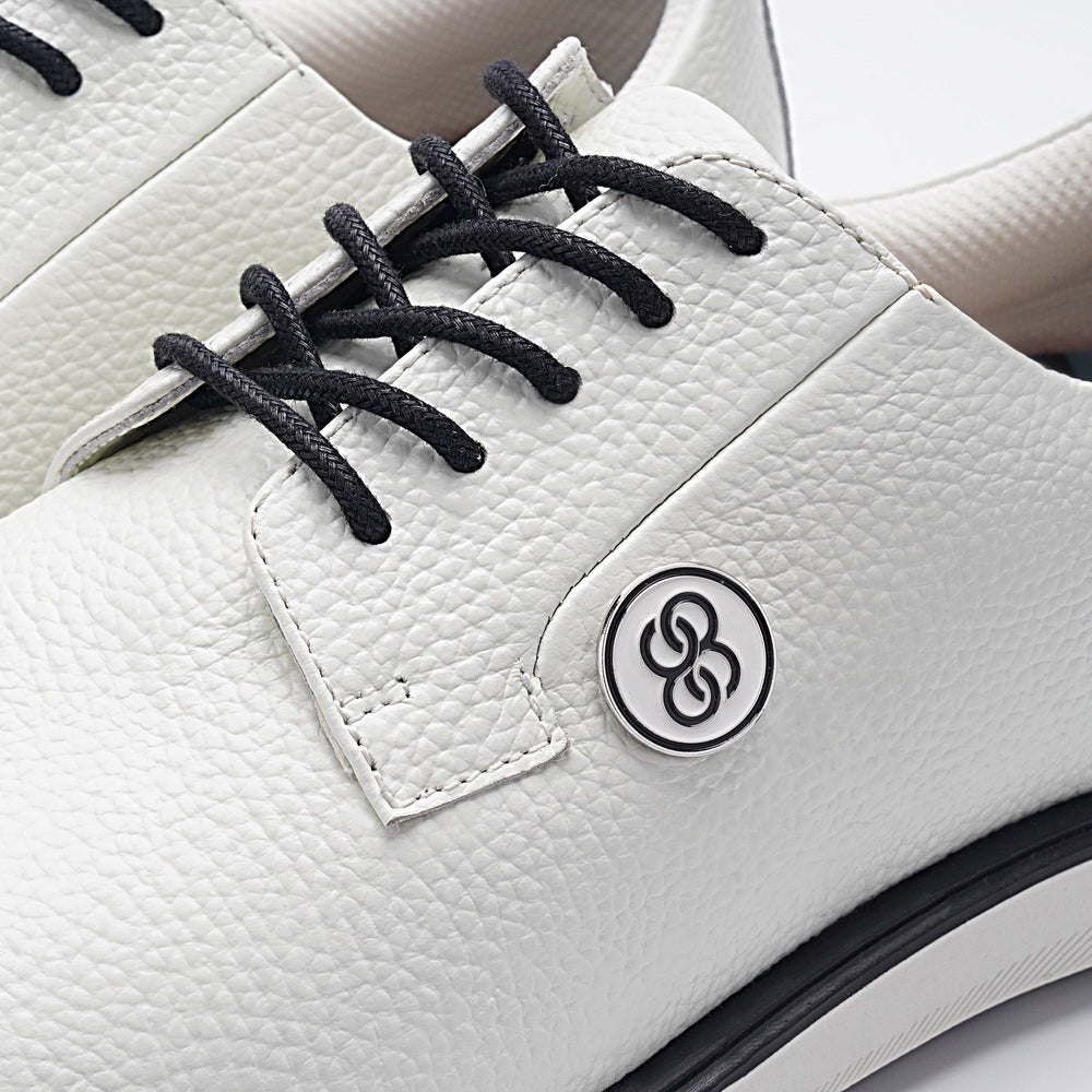 White shoe with black laces and a logo on a white background sells at Paradise Golf