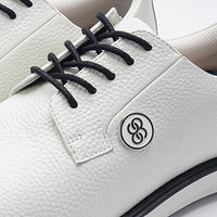 White shoe with black laces and a logo on a white background sells at Paradise Golf