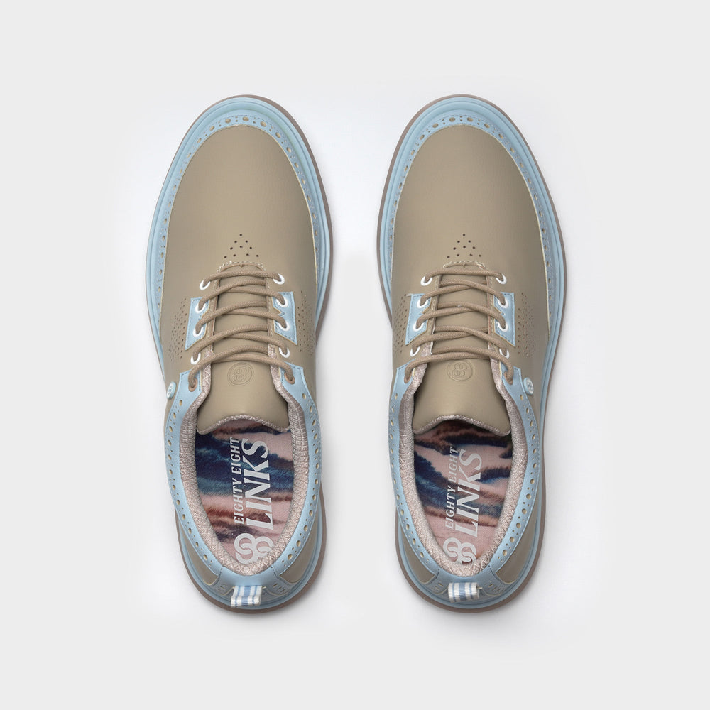Pair of beige shoes with blue soles on a white background sells at Paradise Golf